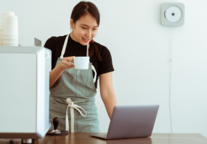 personnage buvant un café en regardant un pc